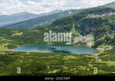 Panorama sur la montagne de Rila en un voyage pour sept lacs de Rila. Bulgarie. Le lac inférieur est le plus bas des sept lacs Rila. Banque D'Images