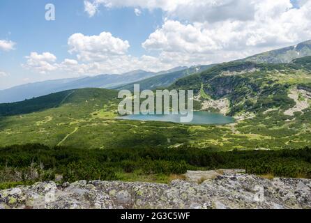 Panorama sur la montagne de Rila en un voyage pour sept lacs de Rila. Bulgarie. Le lac inférieur est le plus bas des sept lacs Rila. Banque D'Images