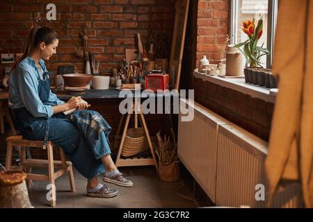 Une jeune femme artisanale du Caucase passe du temps dans un atelier de poterie Banque D'Images