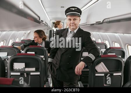 Pilote et hôtesses dans la cabine passager de l'avion Banque D'Images