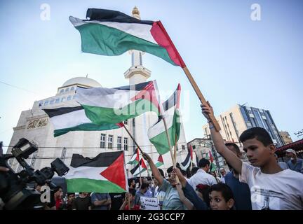 Gaza, Palestine. 15 juin 2021. Des manifestants agitant des drapeaux palestiniens lors d'une manifestation dans le sud de la bande de Gaza, contre la « marche du drapeau » organisée par des colons israéliens d'extrême-droite à Jérusalem-est. Crédit : SOPA Images Limited/Alamy Live News Banque D'Images