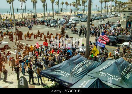 Les députés du shérif monté arrivent alors que les partisans caucasiens de Donald Trump se réunissent pour protester contre sa défaite électorale de 2020 à Huntington Beach, en Californie. Banque D'Images