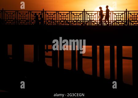 Wiesbaden, Allemagne. 15 juin 2021. Les gens qui marchent à travers le pont Theodor Heuss au coucher du soleil. Credit: Sebastian Gollnow/dpa/Alay Live News Banque D'Images