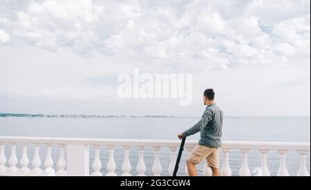 Un homme méconnaissable repose sur un scooter électrique. Banque D'Images