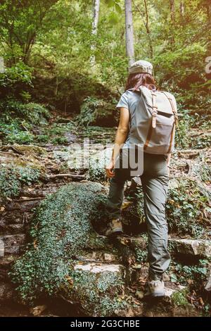 Femme sur une randonnée le long d'un sentier forestier. Banque D'Images