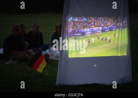 Wiesbaden, Allemagne. 15 juin 2021. Les fans de football regardent le championnat d'Europe match entre l'Allemagne et la France dans un parc avec un beamer. Credit: Sebastian Gollnow/dpa/Alay Live News Banque D'Images