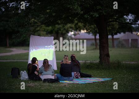 Wiesbaden, Allemagne. 15 juin 2021. Les fans de football regardent le championnat d'Europe match entre l'Allemagne et la France dans un parc avec un beamer. Credit: Sebastian Gollnow/dpa/Alay Live News Banque D'Images