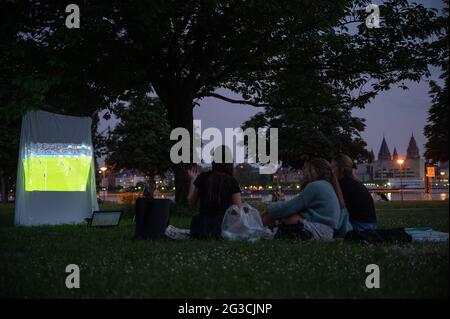 Wiesbaden, Allemagne. 15 juin 2021. Les jeunes femmes regardent le match du Championnat d'Europe entre l'Allemagne et la France dans un parc avec un beamer. Credit: Sebastian Gollnow/dpa/Alay Live News Banque D'Images