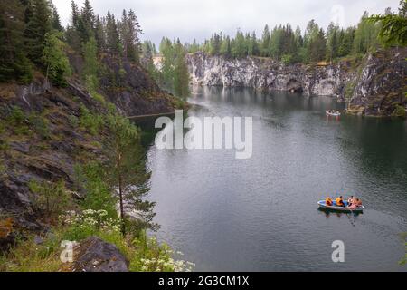 Ruskeala, Russie - 12 juin 2021 : paysage de Karelian avec des touristes dans un bateau naviguant à travers une ancienne carrière de marbre remplie d'eau souterraine Banque D'Images