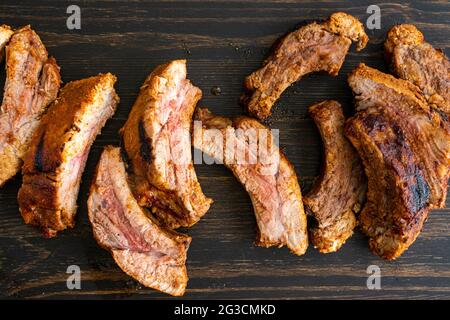 Barbecue bébé côtes de dos sur une table en bois: Côtes de dos de porc sur un fond en bois foncé Banque D'Images