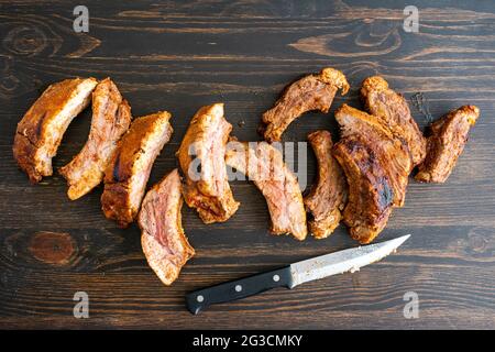 Barbecue bébé côtes de dos sur une table en bois: Côtes de dos de porc sur un fond en bois foncé Banque D'Images