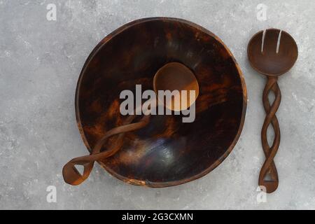 Assiette ronde en bois marron fabriquée à la main vide sur fond de béton de pierre, vue de dessus Banque D'Images