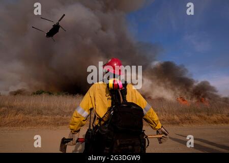 Los Angeles, Californie, États-Unis. 15 juin 2021. Un pompier regarde un hélicoptère se préparer à larguer de l'eau lors d'un feu de broussailles dans l'aire de loisirs du barrage de Santa Fe, à Irwindle, en Californie, le mardi 15 juin, 2021. Credit: Ringo Chiu/ZUMA Wire/Alay Live News Banque D'Images