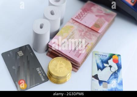 Pile de cent mille billets de rupiah avec les cartes de crédit et bitcoins DE LA BANQUE BRI et aussi une machine EDC (SAISIE ÉLECTRONIQUE DE DONNÉES BANQUE BRI), Th Banque D'Images