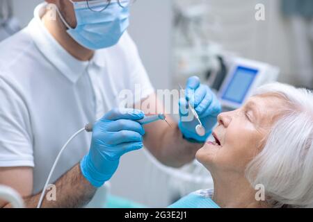 Dentiste rétablissant les dents à la patiente senior Banque D'Images