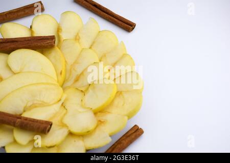 Tranches de pommes blanches et de cannelle sur fond blanc Banque D'Images