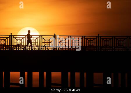 Wiesbaden, Allemagne. 15 juin 2021. Un homme traverse le pont Theodor Heuss au coucher du soleil. Credit: Sebastian Gollnow/dpa/Alay Live News Banque D'Images