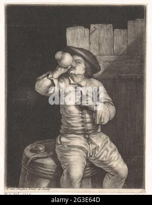 Boire un homme sur une tonne. Un homme avec un tuyau en main est assis sur un baril et des boissons d'une bidon. Banque D'Images