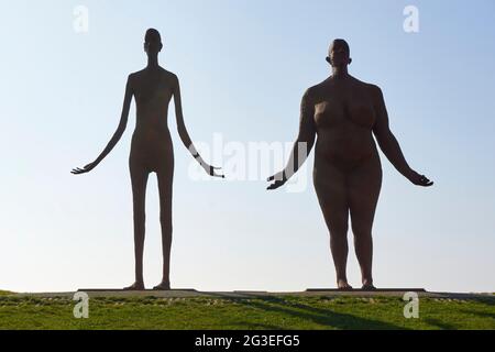 Une statue de Jan Ketelaar, sur le sentier côtier près de Holwerd, attend la marée haute. Les deux femmes en métal soudé, de cinq mètres de haut, regardent au-dessus de la mer. Banque D'Images