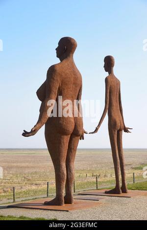 Une statue de Jan Ketelaar, sur le sentier côtier près de Holwerd, attend la marée haute. Les deux femmes en métal soudé, de cinq mètres de haut, regardent au-dessus de la mer. Banque D'Images