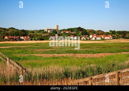 Vue sur les marais de Salthouse jusqu'au village côtier et à l'église de North Norfolk à Salthouse, Norfolk, Angleterre, Royaume-Uni. Banque D'Images