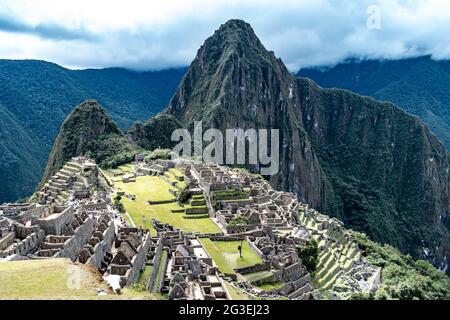 La vue classique du complexe archéologique de Machu Picchu, Vallée Sacrée, Pérou contre un ciel nuageux typique Banque D'Images