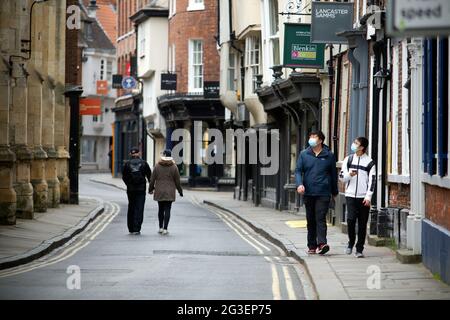 Deux hommes portant un masque facial de protection se prominent dans des rues commerçantes vides du centre-ville de York, dans le nord du Yorkshire. York est une ville qui prospère sur le tourisme Banque D'Images