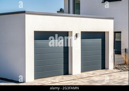 Garage double moderne avec des portes sectionnelles comme un espace de stationnement sécurisé dans votre propre maison Banque D'Images