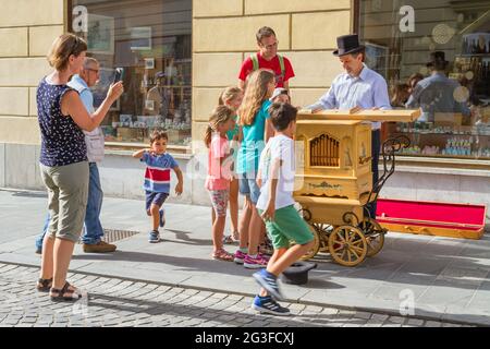 Ljubljana, Slovénie - 15 août 2018 : les touristes apprécient un spectacle de musique traditionnelle dans la rue avec un vieux instrument en bois dans le centre-ville Banque D'Images