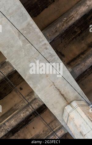 Structure en béton armé de la voie de passage d'autoroute. Fissures des poutres en béton sous le pont. Vue de bas en bas. Banque D'Images