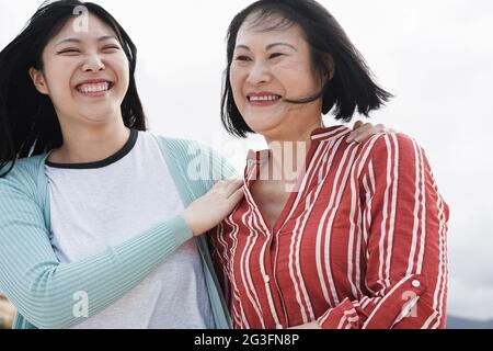 Mère asiatique et fille ayant l'amusement extérieur dans la ville - foyer principal sur le visage de la mère Banque D'Images