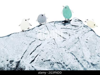 petits pingouins drôles faits d'un morceau de seaglass, avec des jambes et un bec dessinés à l'aide de croquis, sur un iceberg d'une pièce de glace isolée sur fond blanc Banque D'Images
