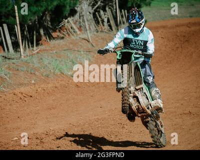 Motard faisant une roue sur une piste de terre Banque D'Images