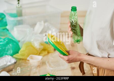 Gros plan d'une femme tenant des déchets de plastique dans ses mains et en les triant Banque D'Images