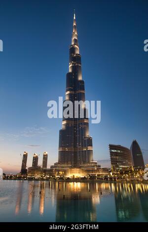 Le bâtiment le plus haut du monde, le Burj Khalifa, illuminé au crépuscule avec des reflets dans le lac en face, Dubaï, Émirats arabes Unis Banque D'Images