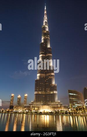 Le bâtiment le plus haut du monde, le Burj Khalifa, illuminé au crépuscule avec des reflets dans le lac en face, Dubaï, Émirats arabes Unis Banque D'Images