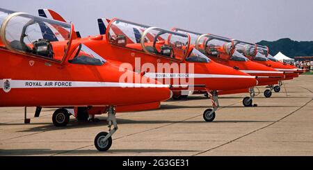 Gros plan 1980 archive View rangée de cinq Red Arrow Royal Air Force RAF avion de vol acrobatique moteur d'équipe Avion militaire d'entraîneur de BAE Hawk rouge blanc et bleu parfaitement aligné avec une auvent de poste de pilotage ouvert sur une position debout en béton À Air Tattoo qui a lieu sur North Weald Airfield une image d'archives près d'Epping dans les années 80 Essex Angleterre Royaume-Uni Banque D'Images