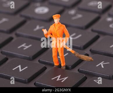 Un travailleur miniature nettoie un clavier Banque D'Images