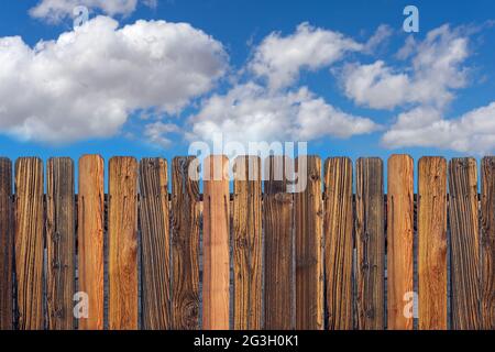 Clôture en bois vieilli avec ciel bleu ciel nuageux Banque D'Images