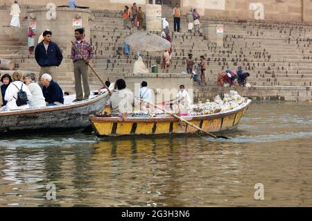 Bateaux tôt le matin et à l'aube de touristes et de vendeurs de souvenirs sur le Gange à Varanasi, Uttar Pradesh, Inde Banque D'Images