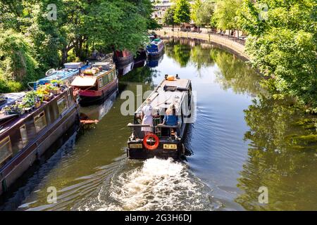 LONDRES ANGLETERRE LITTLE VENICE GRAND UNION CANAL ET REGENT'S CANAL UN BATEAU À RAMES QUI PASSE LE LONG DU SYSTÈME DE CANAUX AU DÉBUT DE L'ÉTÉ Banque D'Images