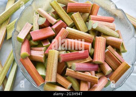 Rhubarbe, 'Rheum rhabarum', tiges récoltées, coupées en tranches pour le désert cuit au four. Banque D'Images