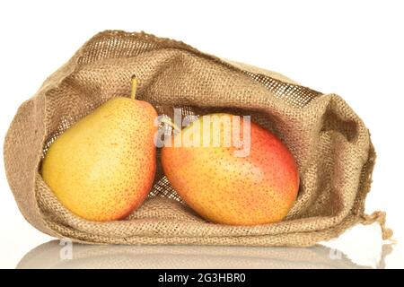 Deux poires bio jaune-rouge dans un sac de jute, sur fond blanc. Banque D'Images