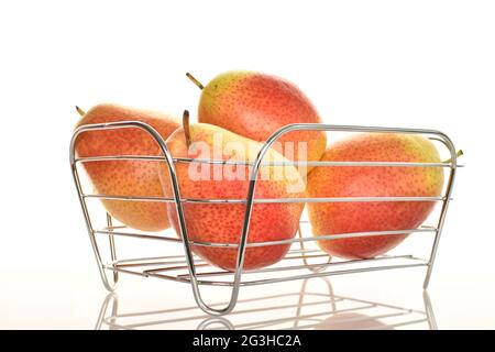 Plusieurs poires bio jaune-rouge dans un panier, gros plan, sur fond blanc. Banque D'Images