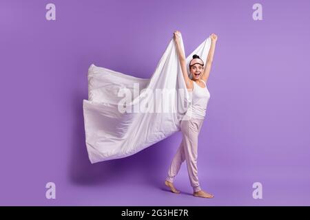 Photo de la taille du corps de la fille sur le pajama partie gardant blanche couverture puildish ludique isolé pastel couleur violet arrière-plan Banque D'Images