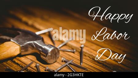 Bon texte de la journée du travail et étoiles contre le marteau et les ongles sur fond de bois Banque D'Images