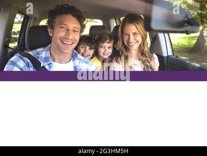 Composition de parents souriants et de deux enfants assis en voiture par beau temps Banque D'Images