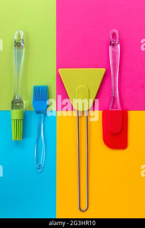 Ustensiles de cuisine. Spatules et brosses en silicone sur fond géométrique coloré Banque D'Images