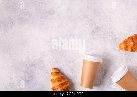 Café à emporter dans une tasse de papier avec croissants, vue de dessus. Banque D'Images
