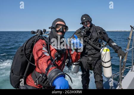 17 avril 2021 - Hamburgsund, Suède : deux plongeurs prêts à entrer dans l'eau. Réservoirs latéraux. Océan et ciel bleu en arrière-plan Banque D'Images